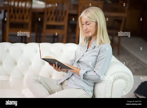 Mature Woman Reading A Book At Home Stock Photo Alamy