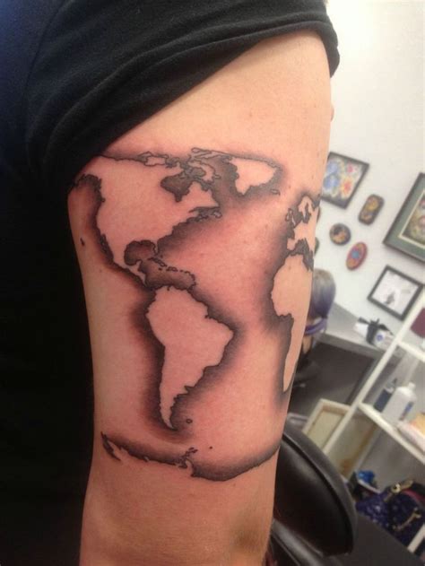 a man's arm with a black and white world map tattoo on it