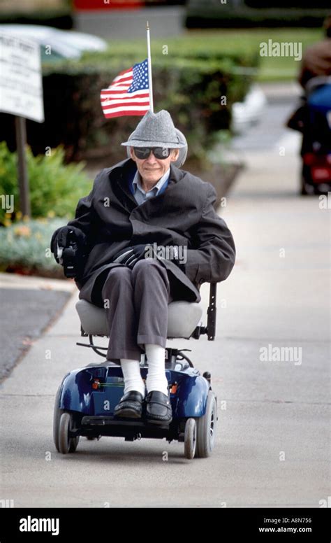 Wheelchair Bound Senior Man On Streets Going About His Business Stock