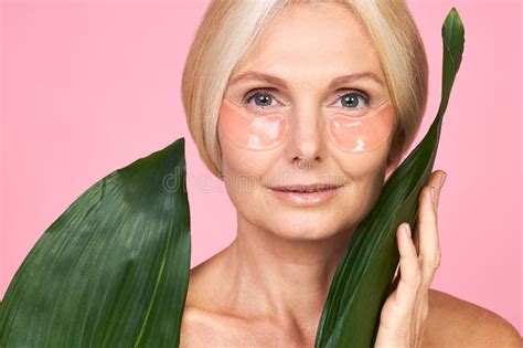 Portrait D Une Dame Mature Avec Patchs Sous Les Yeux Sur Fond Rose