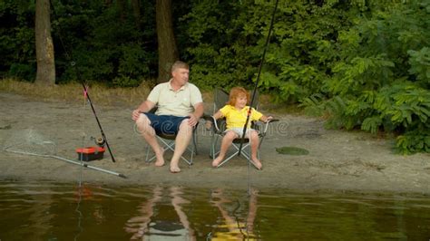 Un Hijo Y Un Padre Lindos Y Relajados Con Barras De Pesca En El Lago