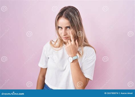 Jeune Femme Blonde Debout Sur Fond Rose Pointant Vers L Oeil Vous Regardant Gester Expression
