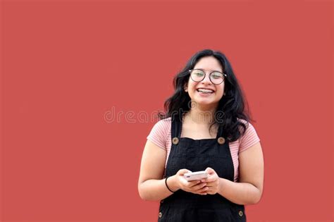 Brunette Latina Teen Woman With Eyeglasses And Brackets Uses Her Cell Phone To Text Shop And