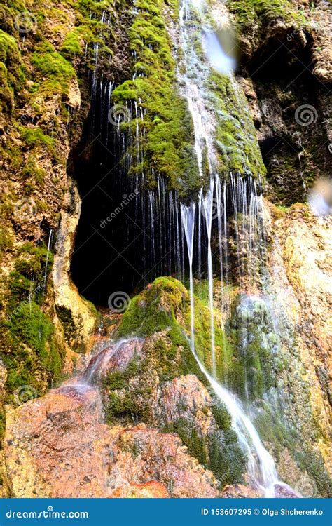 Cave Entrance Hidden Behind a Small Waterfall. Stalactite Cave in the ...