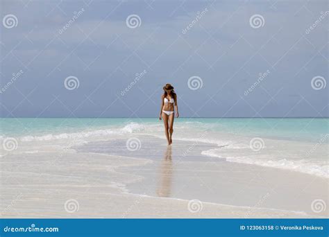 Jeune Femme Dans Le Bikini Blanc Marchant Sur La Plage Photo Stock