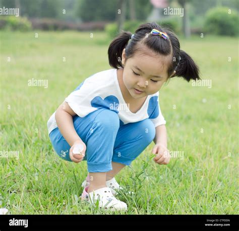 The little girl on the grass flowers Stock Photo - Alamy