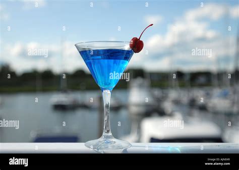 A Fancy Blue Cosmopolitan Drink In A Martini Glass With Cherry Garnish