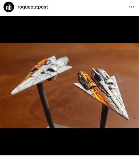 Two Models Of Fighter Jets On Top Of A Wooden Table Next To Each Other