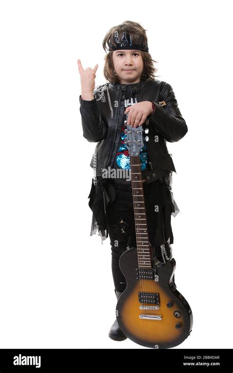 Rockero niño con guitarra eléctrica mostrando el signo de rock aislado