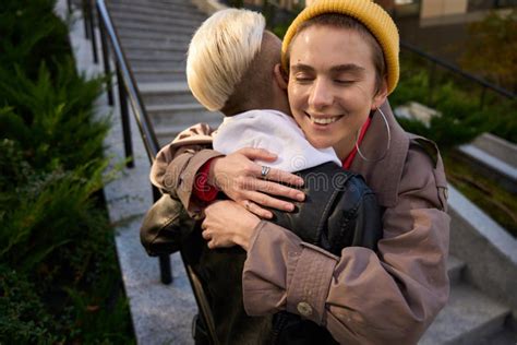 Brunette In Een Geel Kapje Knuffelt Haar Vriendin Warm Stock Foto Image Of Mededeling