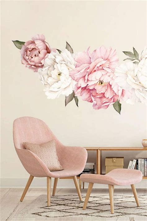 A Living Room With Pink Chairs And Flowers On The Wall