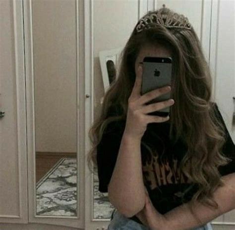 A Woman Taking A Selfie In Front Of A Mirror Wearing A Tiara And Denim