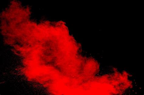 Nube de explosión de polvo rojo sobre fondo negro movimiento congelado