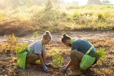 Gente plantando árboles en el campo Foto Gratis