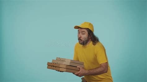 Delivery Man In Yellow Uniform Running Into The Frame With Pizza Boxes