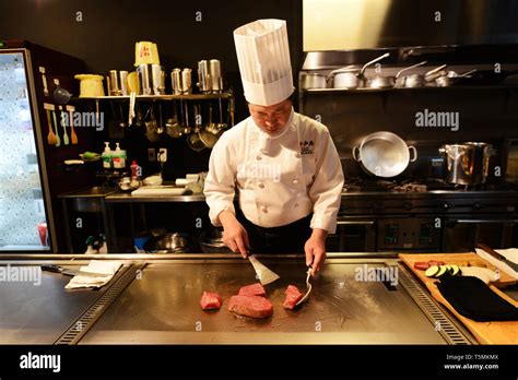 A Japanese Teppanyaki Chef Grilling Kobe Beef Steaks In A Traditional