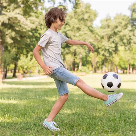 Menino De Vista Lateral Brincando Bola De Futebol Foto Premium