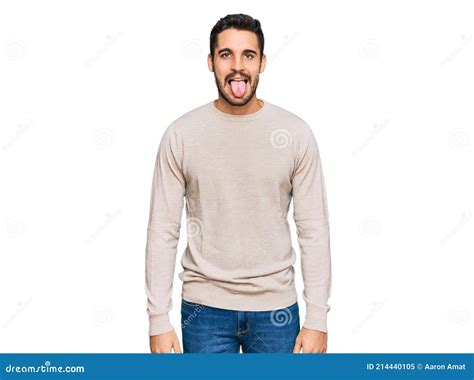 Young Hispanic Man Wearing Casual Clothes Sticking Tongue Out Happy