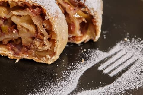 Premium Photo Apple Strudel With Icing Sugar On Black Plate Wooden Wall