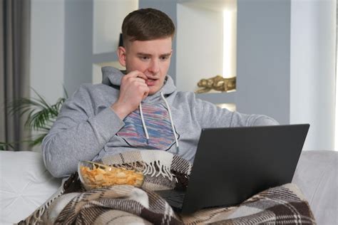 Premium Photo | Caucasian man watching a movie on his laptop in the sofa