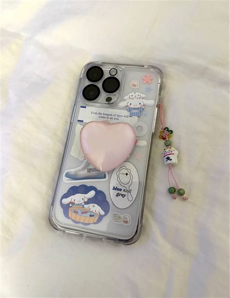 An Iphone Case With Some Stickers On It And A Cell Phone In The Background