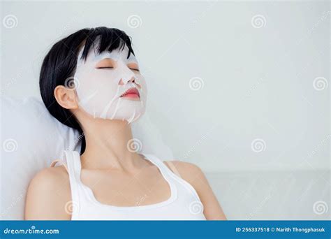 Beautiful Young Asian Woman With Sheet Facial Mask And Sleep On Bed At