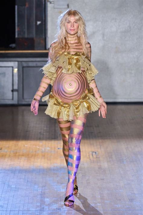 A Woman Walking Down A Runway Wearing Tights And Stockings With An