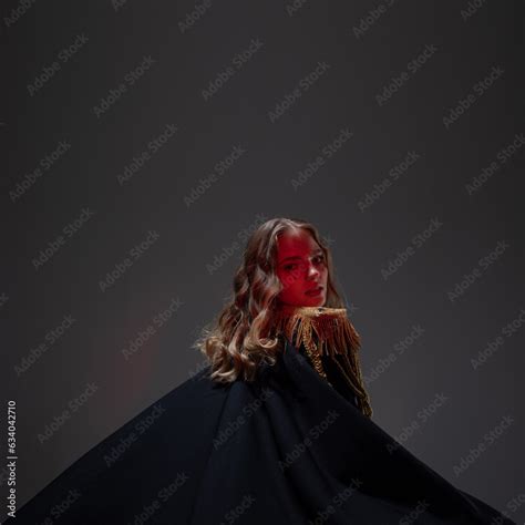 A Glamorous Blonde In A Carnival Uniform With Epaulettes Waving A Raincoat The Host Of The