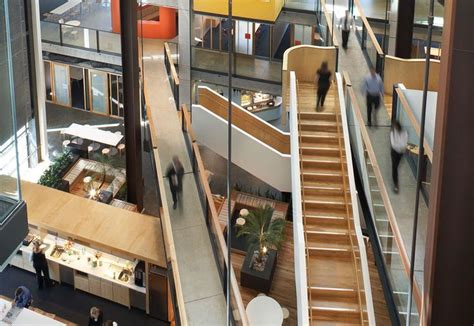 People Are Walking Up And Down The Escalators In An Office Building