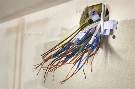 Electrical Exposed Connected Wires Protruding From Socket On White Wall