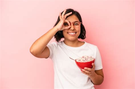 Mujer Latina Joven Con Cereales Aislados Sobre Fondo Rosa Emocionado Manteniendo El Gesto Ok En