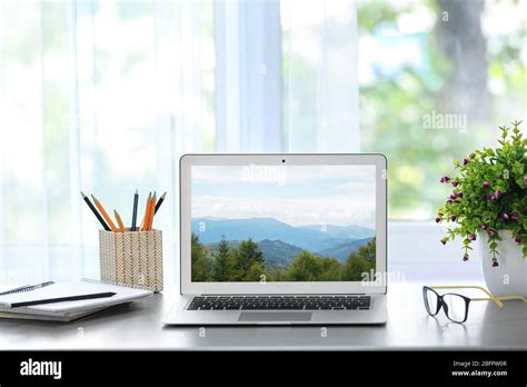 Workplace with laptop and wallpaper of landscape on screen Stock Photo ...