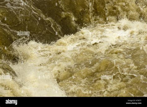 The River Avon In Flood Ruishes Over The Pulteney Weir In Bath Somerset