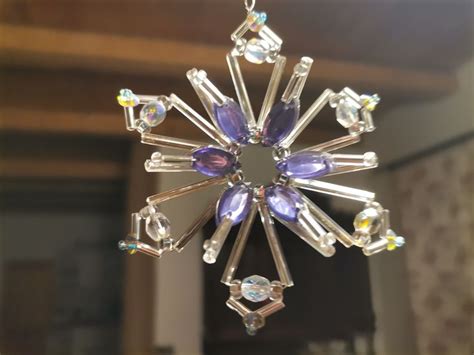 A Glass Snowflake Hanging From A Ceiling