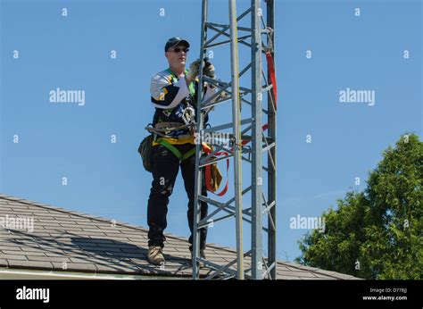 Man climbing antenna tower during amateur radio tower installation Stock Photo - Alamy