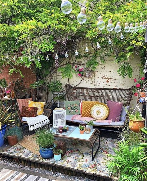 An Outdoor Seating Area With Lots Of Plants And Potted Plants On The