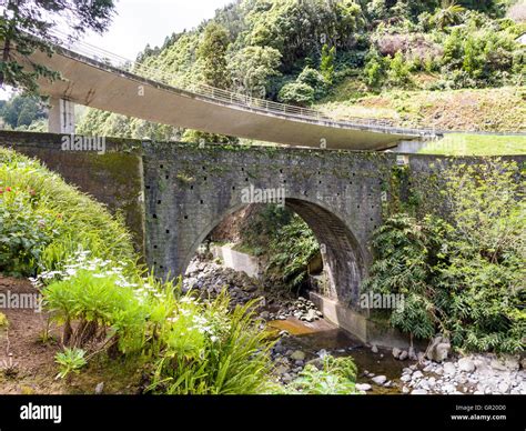 Old And New Bridges An Old Stone Arched Bridge Over A Stream With A