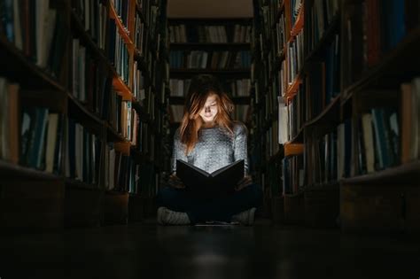 Premium Photo Girl Reading A Book In The Library Sitting On The Floor