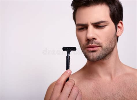 Naakte Brunette Staat Op Witte Achtergrond Met Zwarte Scheermes In Zijn Hand Stock Afbeelding