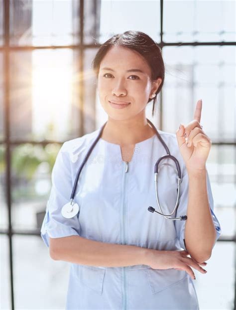 Portrait Of Asian Female Doctor Showing Thumbs Up And Smiling Stock