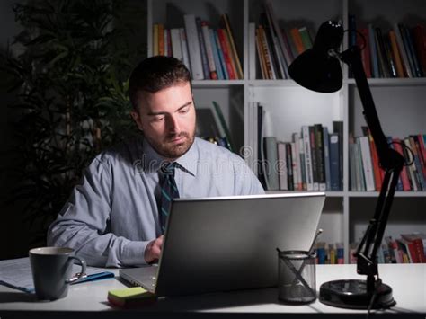 Businessman Working And Watching Laptop Display At Night Stock Image