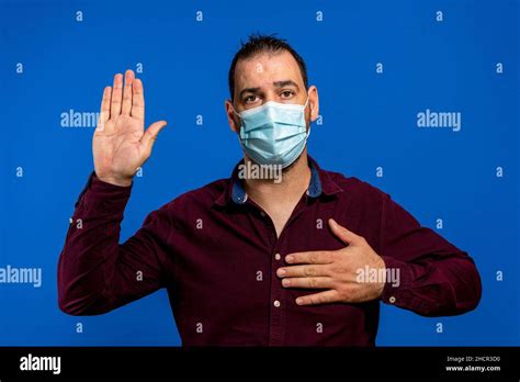 Portrait Of Serious Brunette Man With Surgical Medical Mask Standing