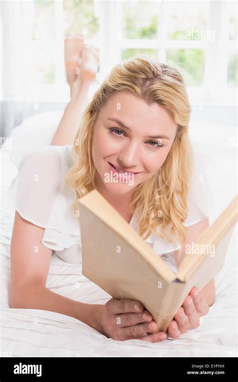 Pretty Blonde Lying On Bed Smiling At Camera With Book Stock Photo Alamy