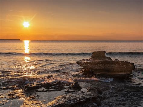 Premium Photo | A sunset over the ocean with a boat in the background