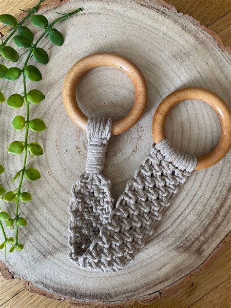 Two Knitted Wooden Toys Sitting On Top Of A Piece Of Wood Next To A Plant