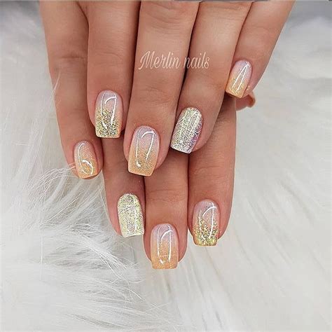 A Woman S Hand With Gold And White Manies On Her Nails Which Are