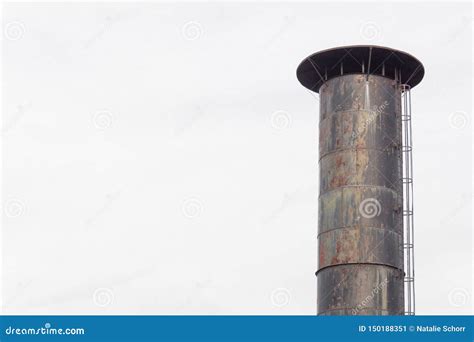 Top Of A Smokestack With Exterior Mounted Caged Ladder Isolated Against