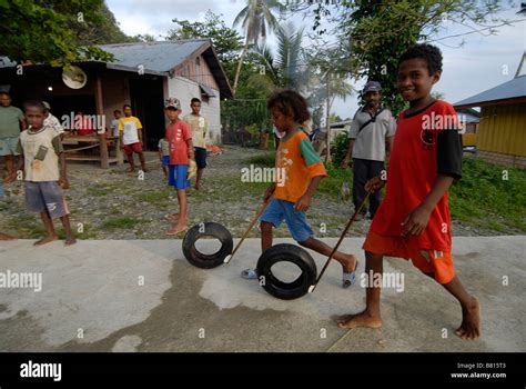 Kids Playing With Wheels And Sticks In Korido On Biak Island Indonesia