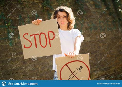 Young Protesting Woman In White Shirt And Jeans Holds Protest Sign