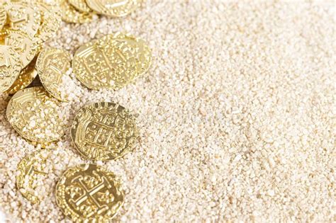 Buried Pirate Treasure Gold Coins in the Sand on a Sandy Beach Stock ...